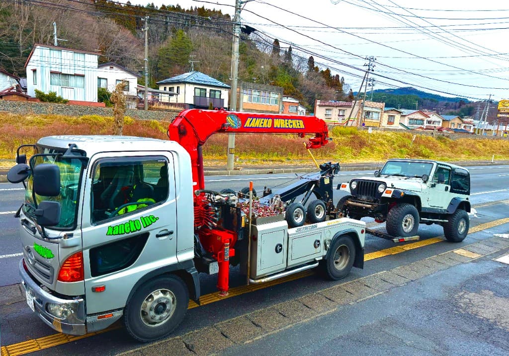 レッカー車が四輪車を牽引する作業風景